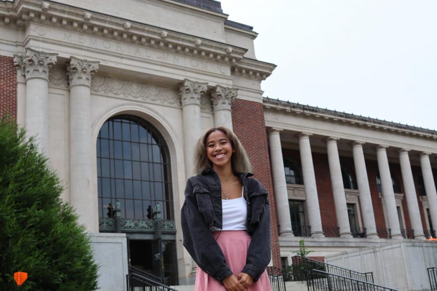 A woman stands in front of the Memorial Union on the Oregon State University campus.